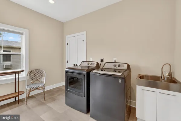 a utility room with sink dryer and washer