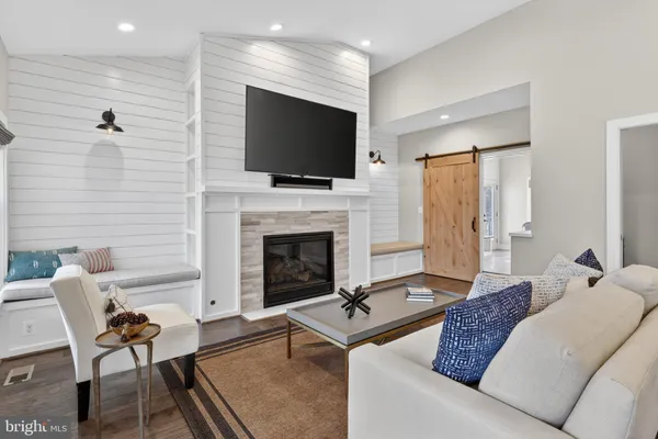 a living room with furniture a flat screen tv and a fireplace