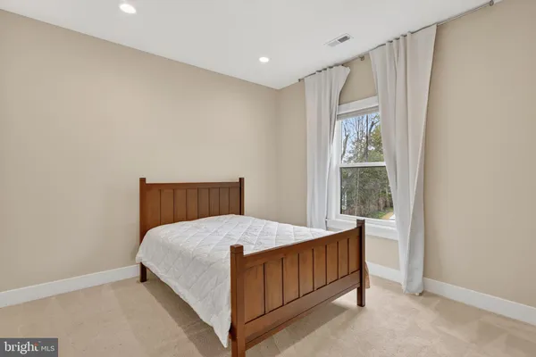 a bed sitting in a bedroom next to a window