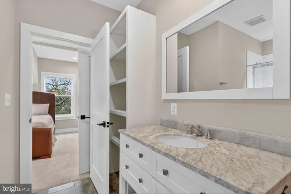 a bathroom with a granite countertop sink and a mirror