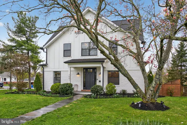 a front view of a house with a garden and trees