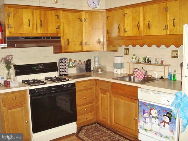 3714 Leverton Street Silver Spring, MD 20906 - Photo 12 of 24 a kitchen with stainless steel appliances a stove a sink and a microwave