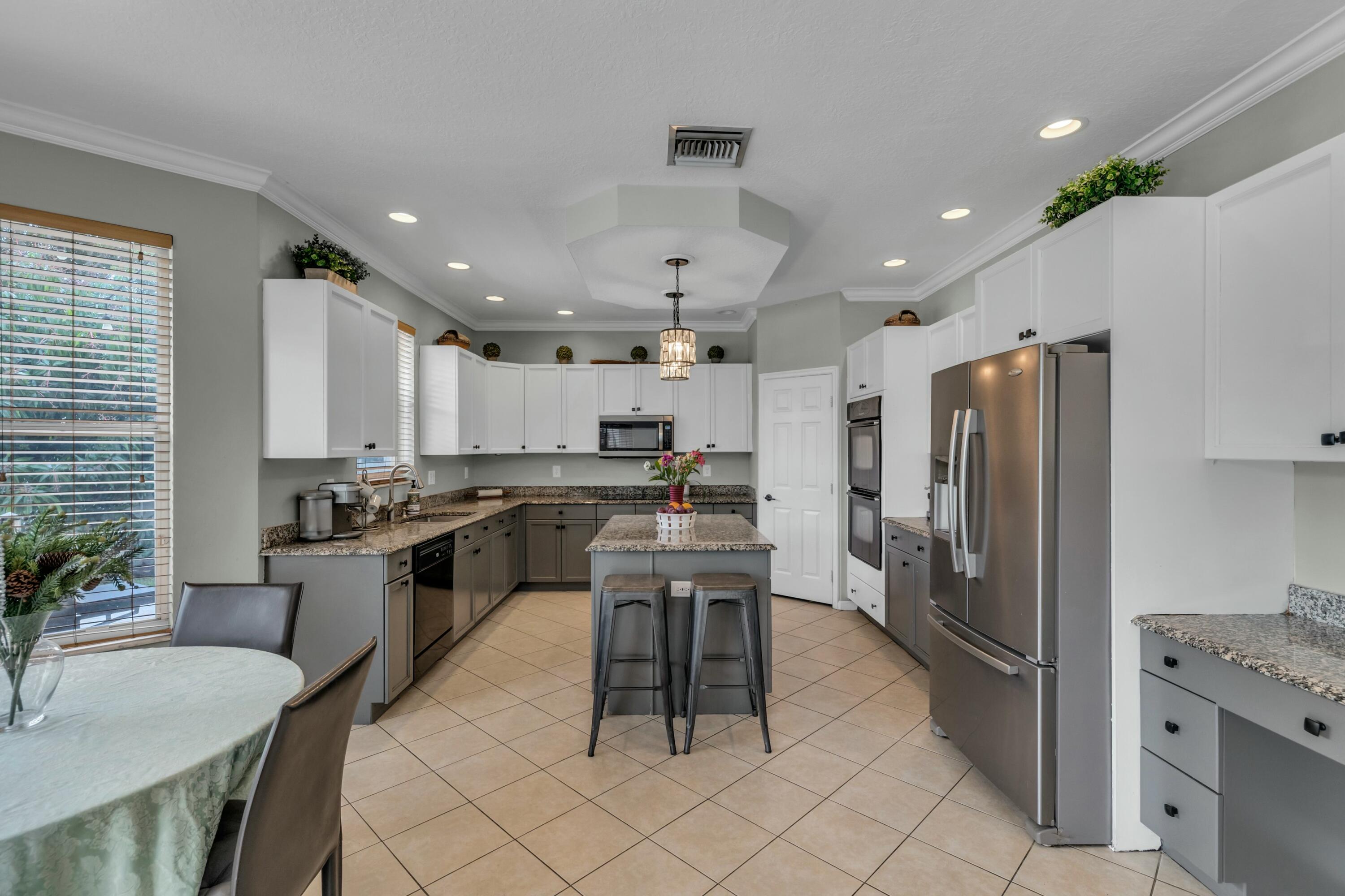9895 Shepard Place Wellington, FL 33414 - Photo 14 of 60 a kitchen with granite countertop a counter space stainless steel appliances and a dining table