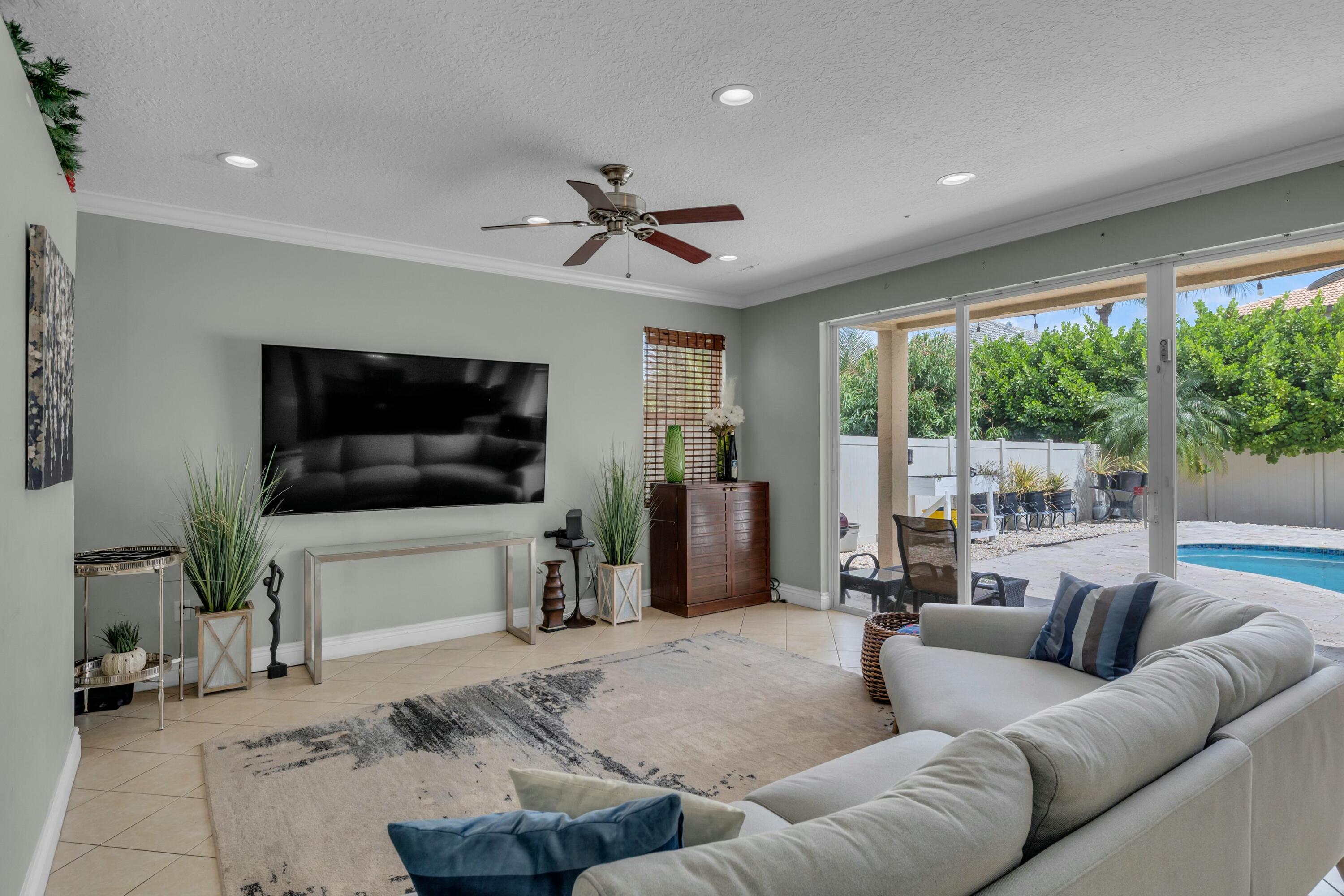 9895 Shepard Place Wellington, FL 33414 - Photo 23 of 60 a living room with furniture and a flat screen tv