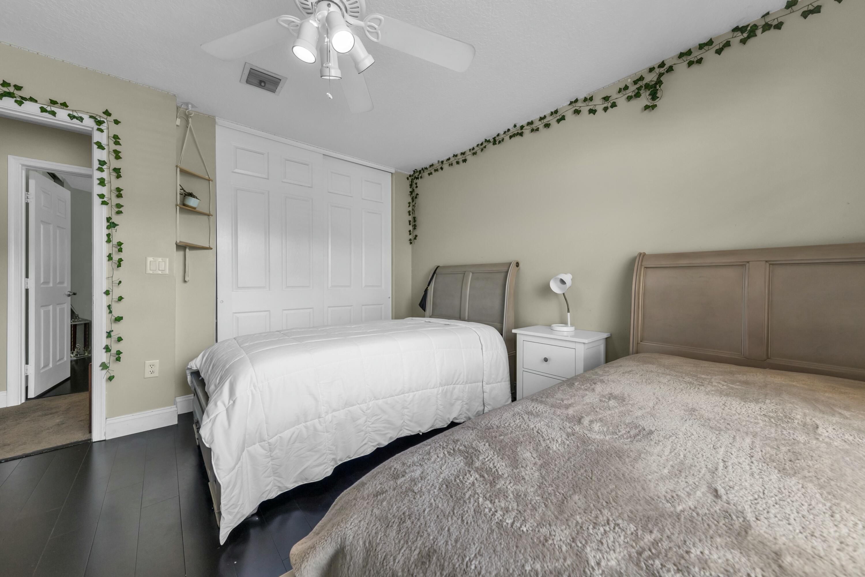 9895 Shepard Place Wellington, FL 33414 - Photo 28 of 60 a bedroom with bed and a chandelier