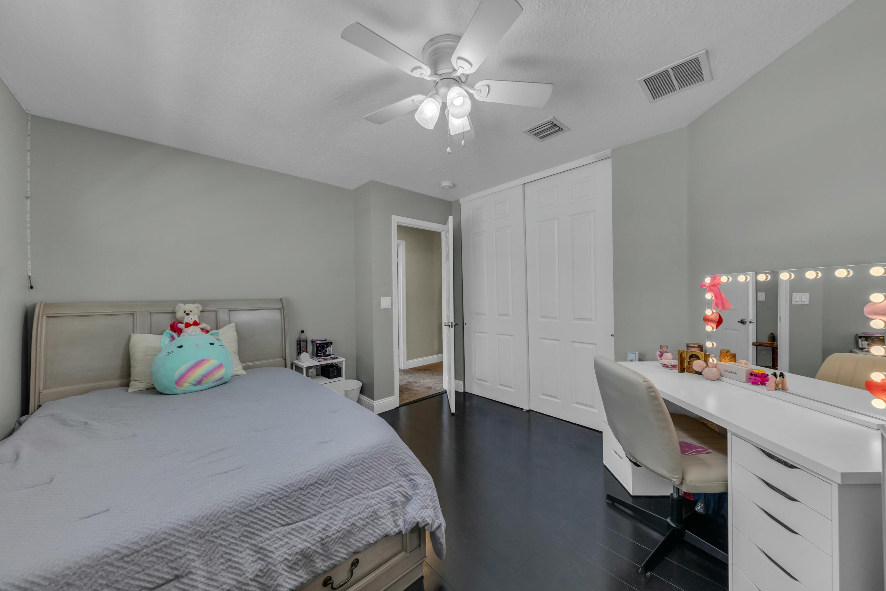 9895 Shepard Place Wellington, FL 33414 - Photo 30 of 60 a bedroom with a bed and a chandelier