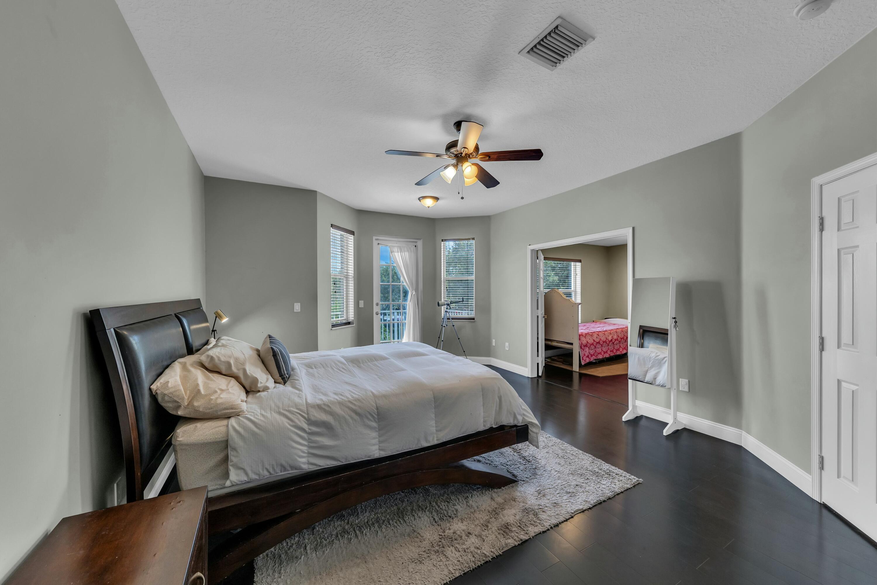 9895 Shepard Place Wellington, FL 33414 - Photo 34 of 60 a bedroom with a bed and a chandelier