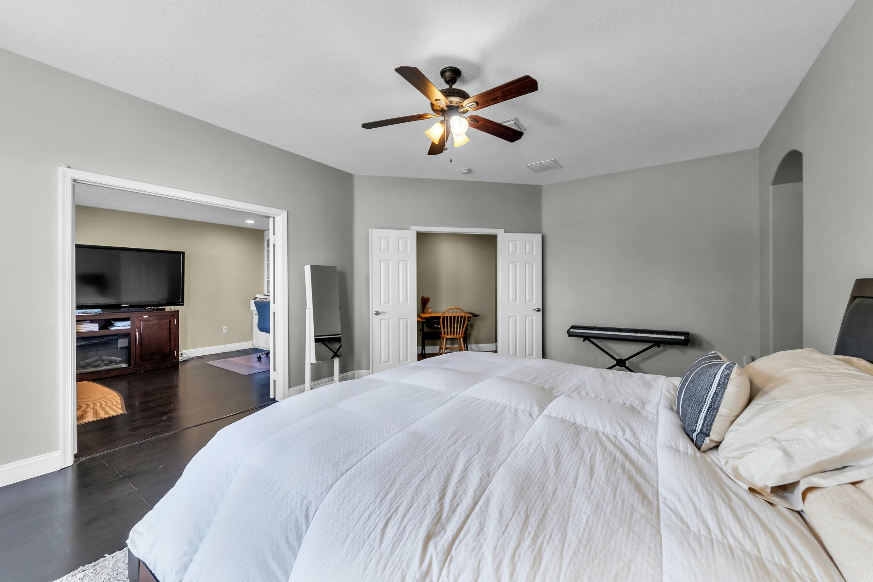 9895 Shepard Place Wellington, FL 33414 - Photo 36 of 60 a bedroom with a large bed and a chandelier