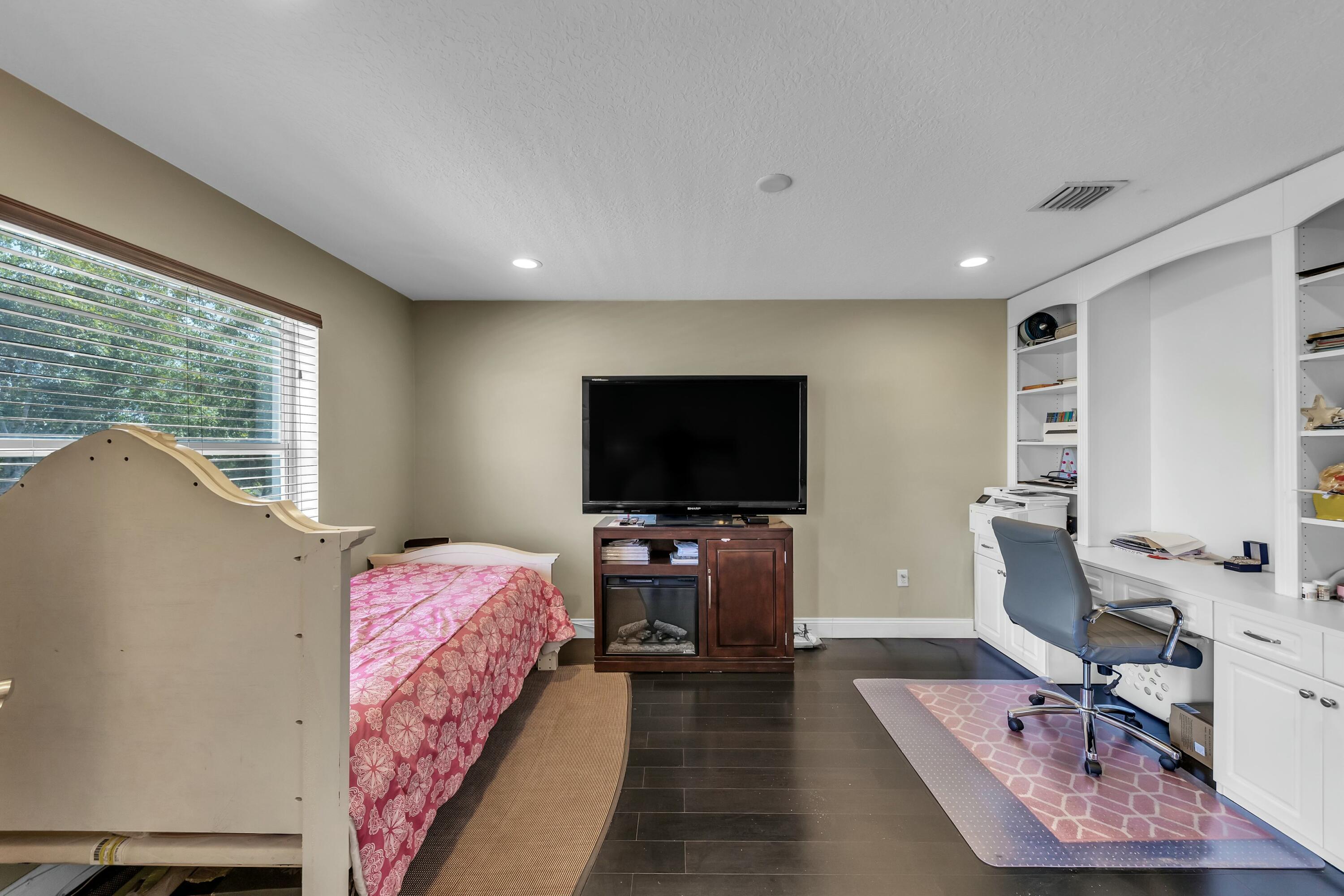 9895 Shepard Place Wellington, FL 33414 - Photo 37 of 60 a bedroom with a bed and a flat screen tv