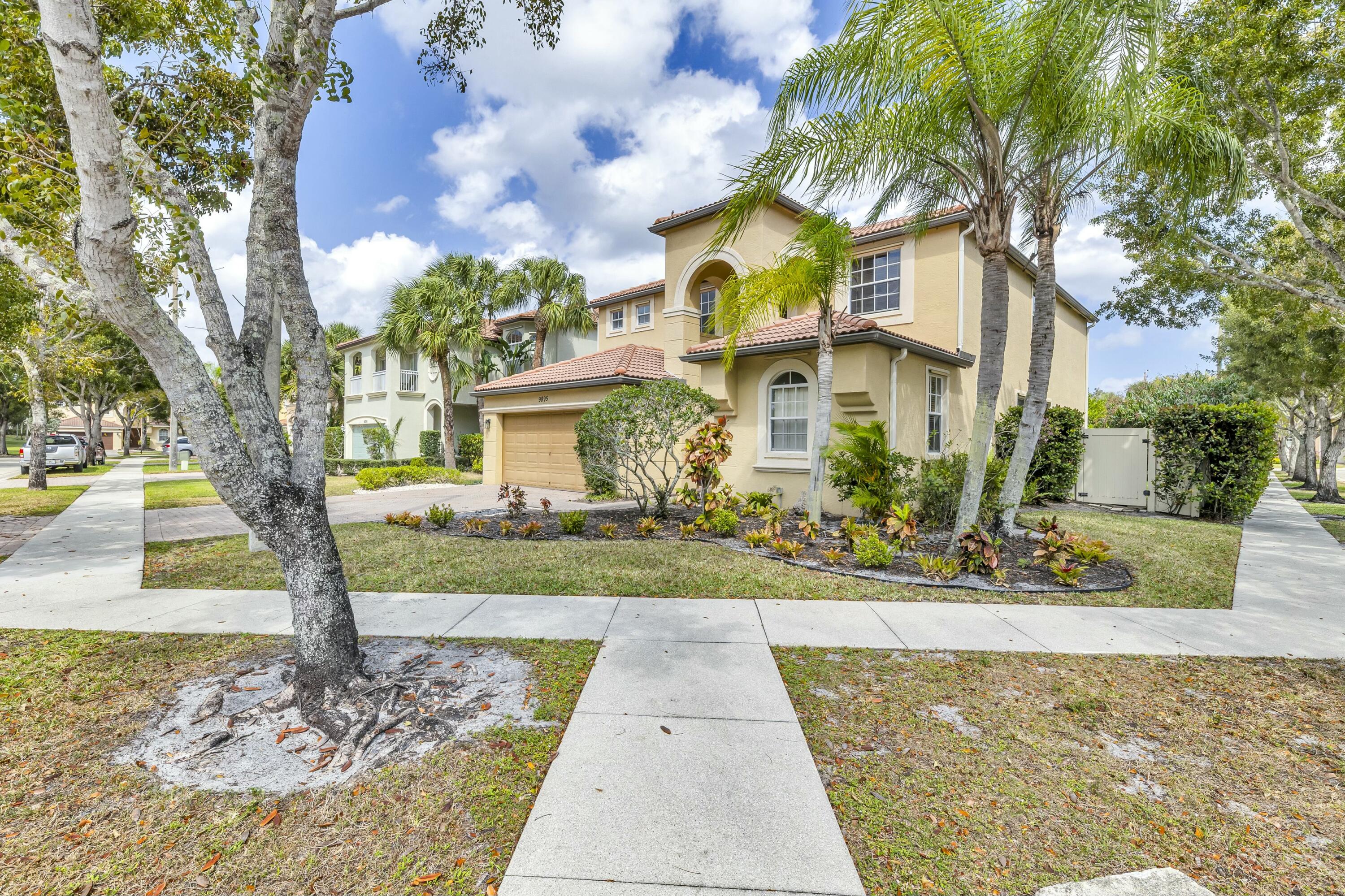 9895 Shepard Place Wellington, FL 33414 - Photo 49 of 60 a front view of a house with garden