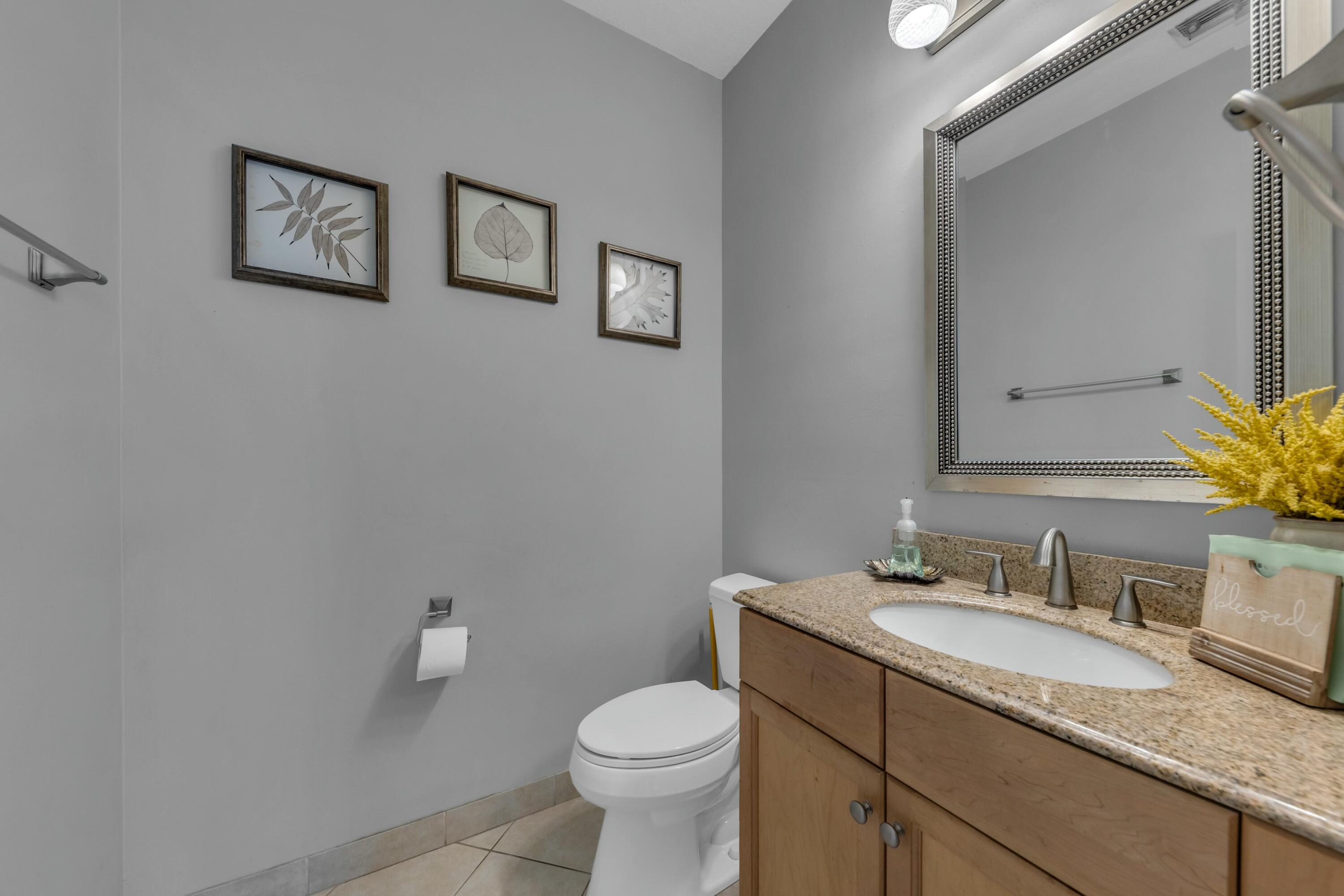 9895 Shepard Place Wellington, FL 33414 - Photo 9 of 60 a bathroom with a granite countertop toilet sink and mirror