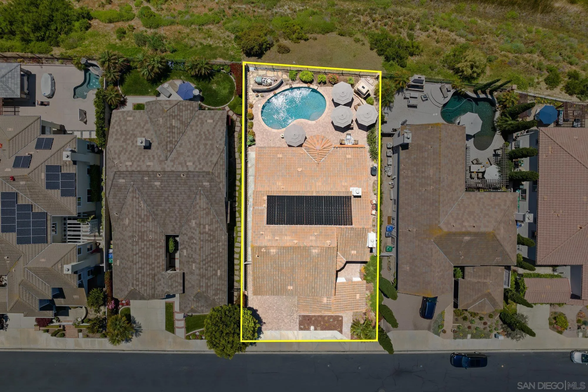 an aerial view of residential houses with outdoor space and parking