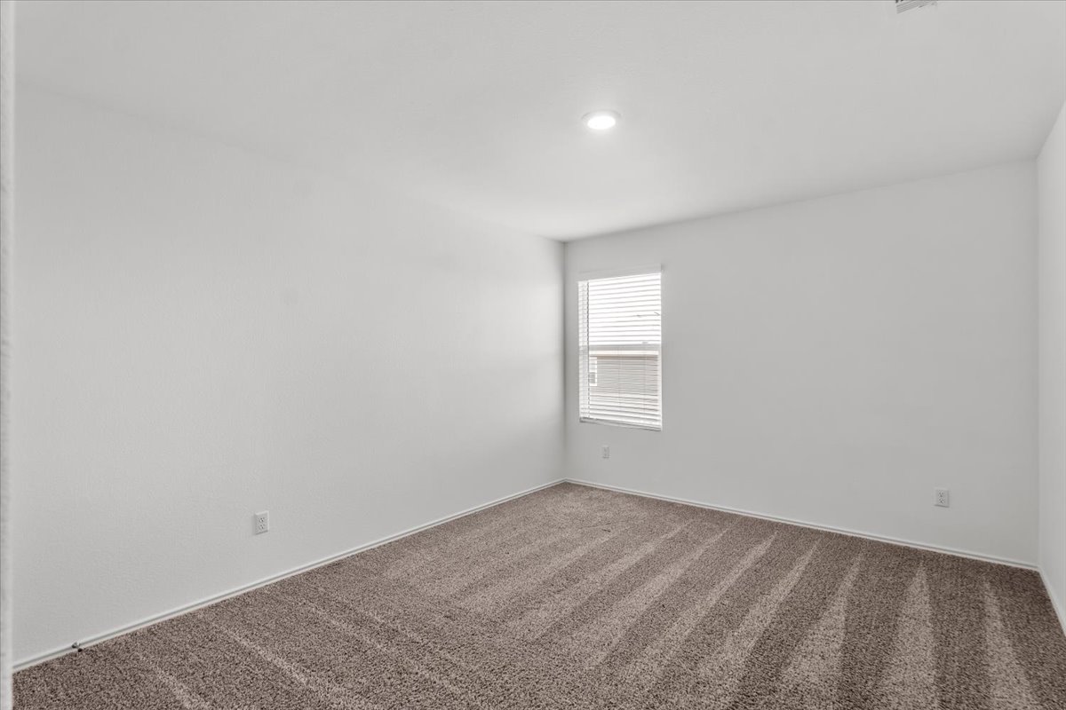448 Perfect World Loop Jarrell, TX 76537 - Photo 36 of 40 A well-lit room offers fresh carpeting and a window with privacy blinds, ready for personalization.