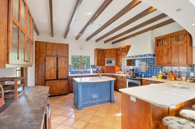 a kitchen with a sink a stove and chairs