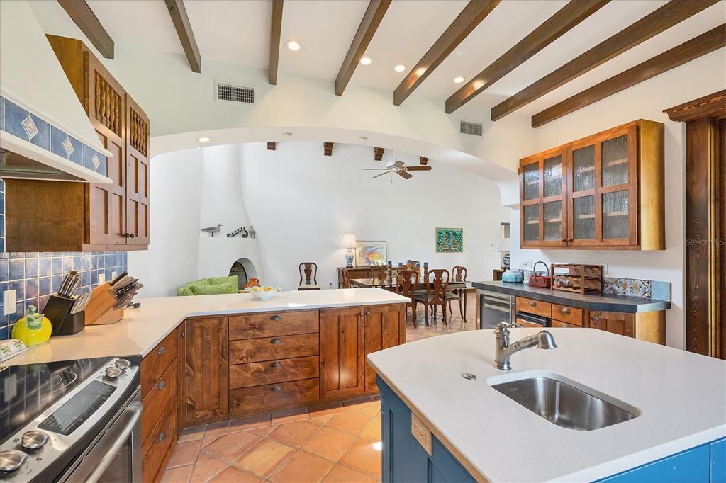 1021 10th Street West Boca Grande, FL 33921 - Photo 13 of 34 a kitchen with a sink a stove and chairs with wooden floor