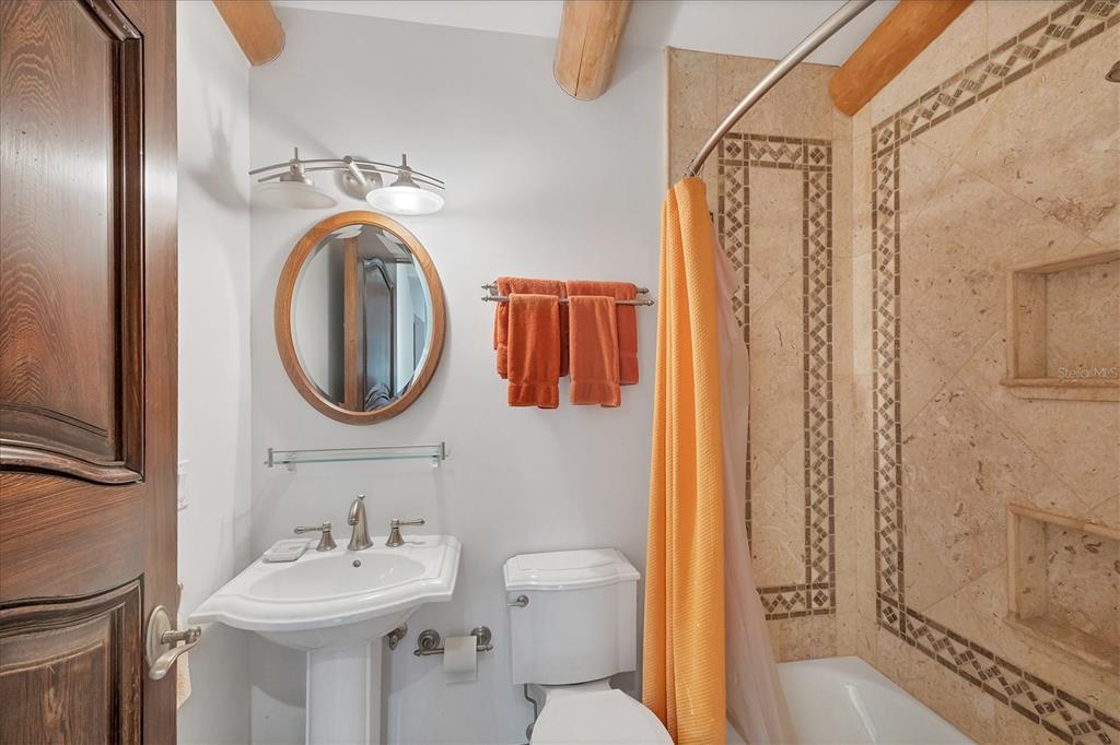 1021 10th Street West Boca Grande, FL 33921 - Photo 15 of 34 a bathroom with a sink a mirror a toilet and a shower