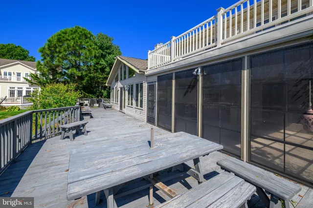 a view of a roof deck with table and chairs with wooden floor and fence