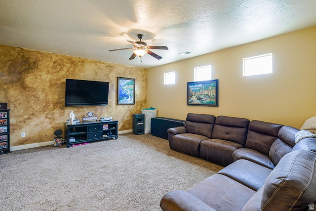 3683 South 2640 West St. George, UT 84790 - Photo 33 of 41 Spacious room featuring textured accent wall, light-colored carpeting, ceiling fan with integrated lighting, and multiple high-set windows