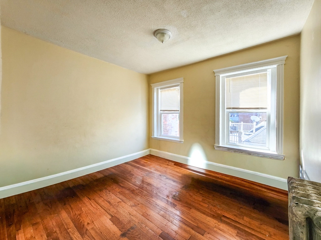 35 Abbotsford Street, Unit 3 Boston, MA 02121 - Photo 4 of 6 a view of an empty room with a window and wooden floor