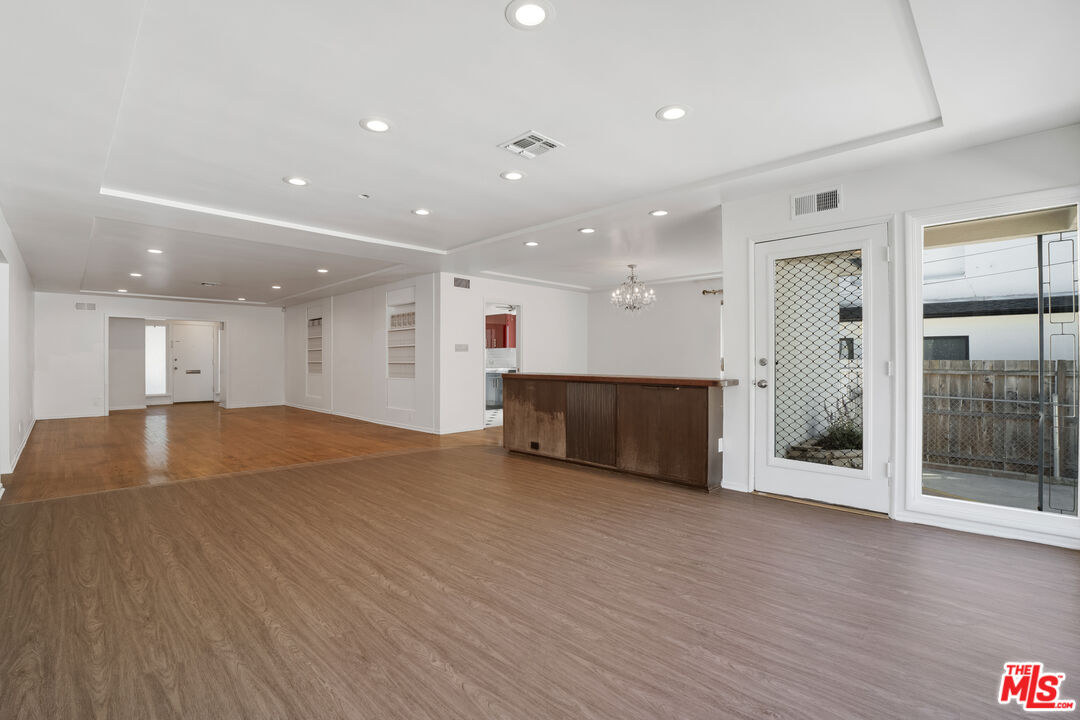 1617 Reeves Street Los Angeles, CA 90035 - Photo 11 of 55 a view of an empty room with wooden floor and kitchen view