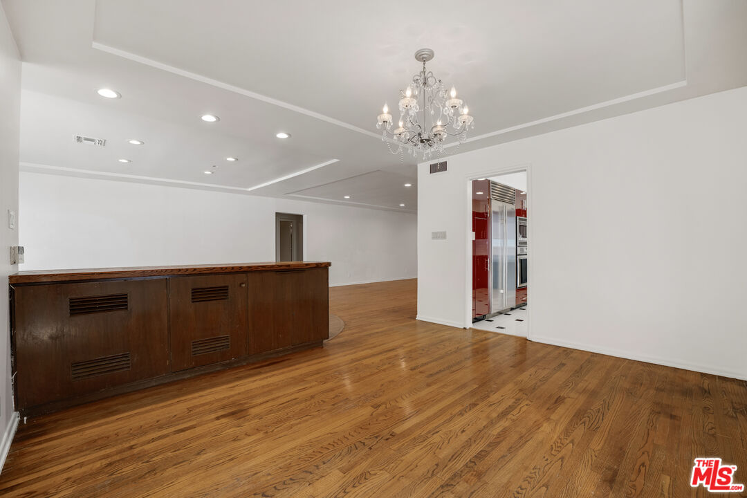 1617 Reeves Street Los Angeles, CA 90035 - Photo 18 of 55 a view of an empty room with wooden floor and a kitchen