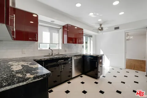 a kitchen with stainless steel appliances kitchen island granite countertop a refrigerator and a stove