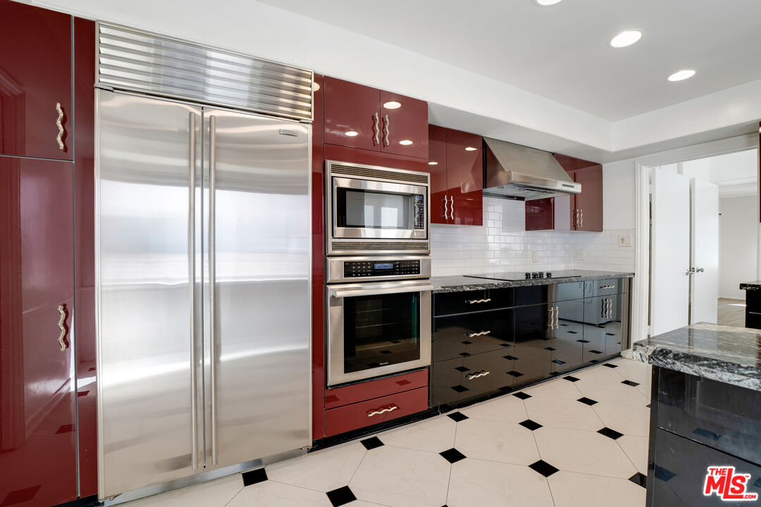 1617 Reeves Street Los Angeles, CA 90035 - Photo 23 of 55 a kitchen with stainless steel appliances kitchen island granite countertop a refrigerator and a stove