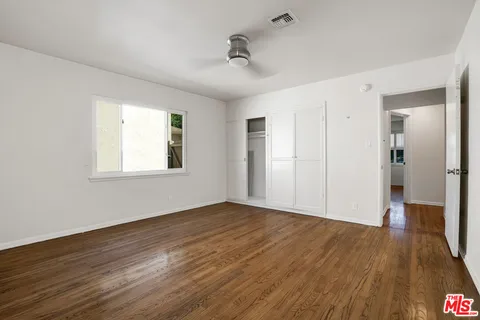 a spacious bedroom with a large bed and a wooden floor