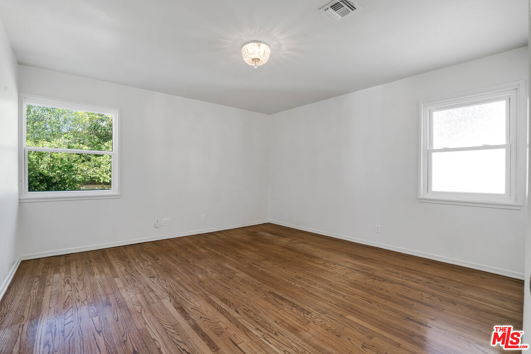 1617 Reeves Street Los Angeles, CA 90035 - Photo 36 of 55 an empty room with wooden floor and windows