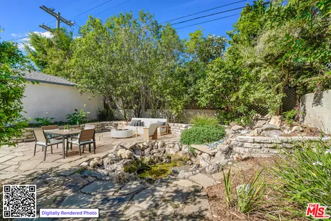 a view of a yard with plants and tree