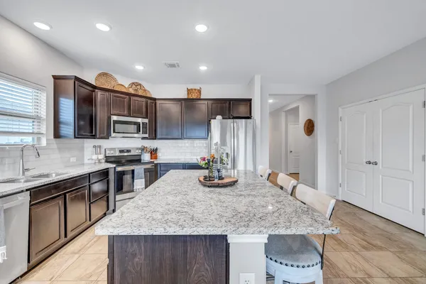 a kitchen with stainless steel appliances granite countertop a sink stove and refrigerator