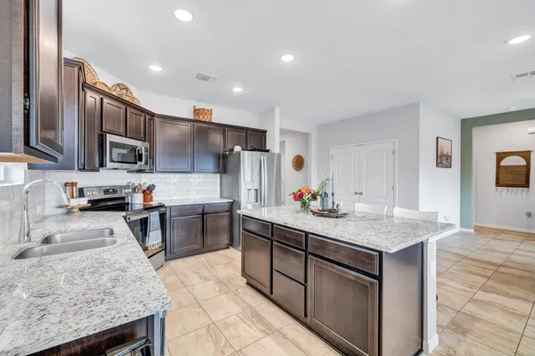 a kitchen with stainless steel appliances granite countertop a sink stove and refrigerator