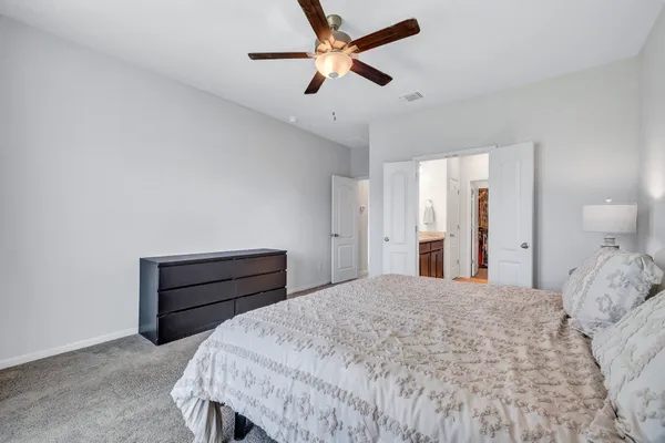 a bedroom with a bed and a ceiling fan