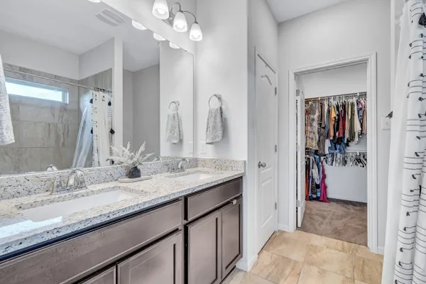 a en suite bathroom with a granite countertop double vanity sink mirror and