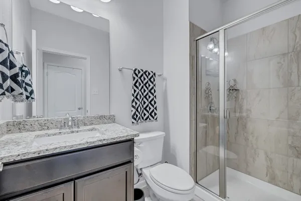 a bathroom with a granite countertop sink toilet and shower