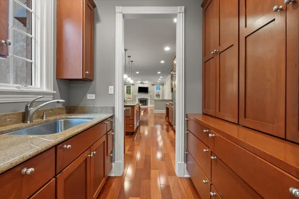 a kitchen with stainless steel appliances granite countertop a refrigerator a stove top oven and a sink with cabinets