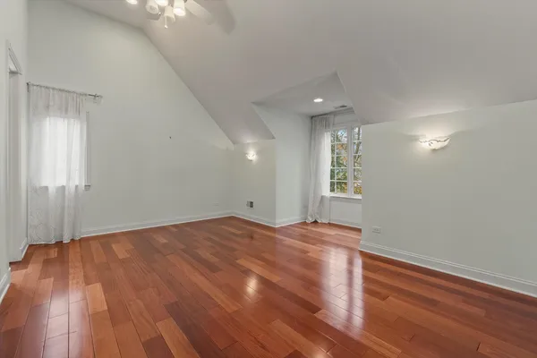 an empty room with a chandelier fan and closet