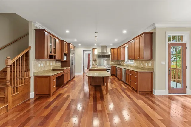 a kitchen with kitchen island granite countertop a stove and a wooden floors