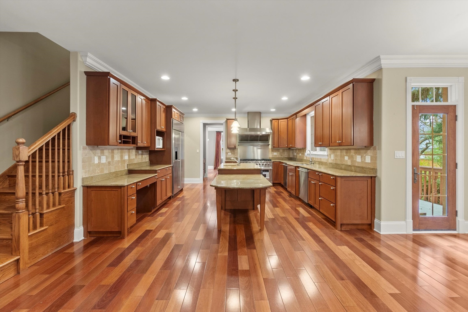 130 Fuller Road Hinsdale, IL 60521 - Photo 9 of 30 a kitchen with stainless steel appliances kitchen island granite countertop wooden floors wooden cabinets and sink
