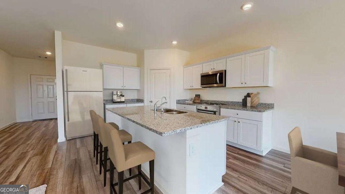 190 Otway Loop Winder, GA 30680 - Photo 4 of 17 a kitchen with a sink a microwave a refrigerator and wooden floor