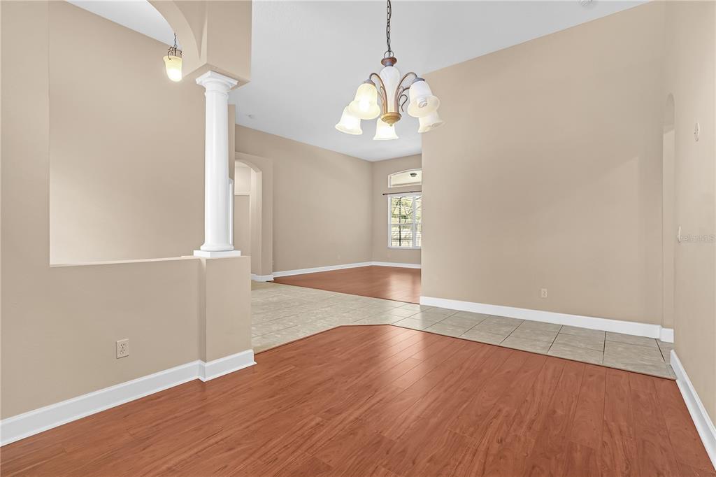 1542 Wescott Loop Winter Springs, FL 32708 - Photo 18 of 62 an empty room with wooden floor chandelier and windows