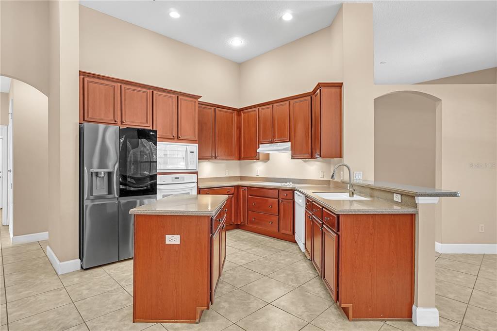 1542 Wescott Loop Winter Springs, FL 32708 - Photo 27 of 62 a kitchen with stainless steel appliances granite countertop a refrigerator stove a sink and dishwasher