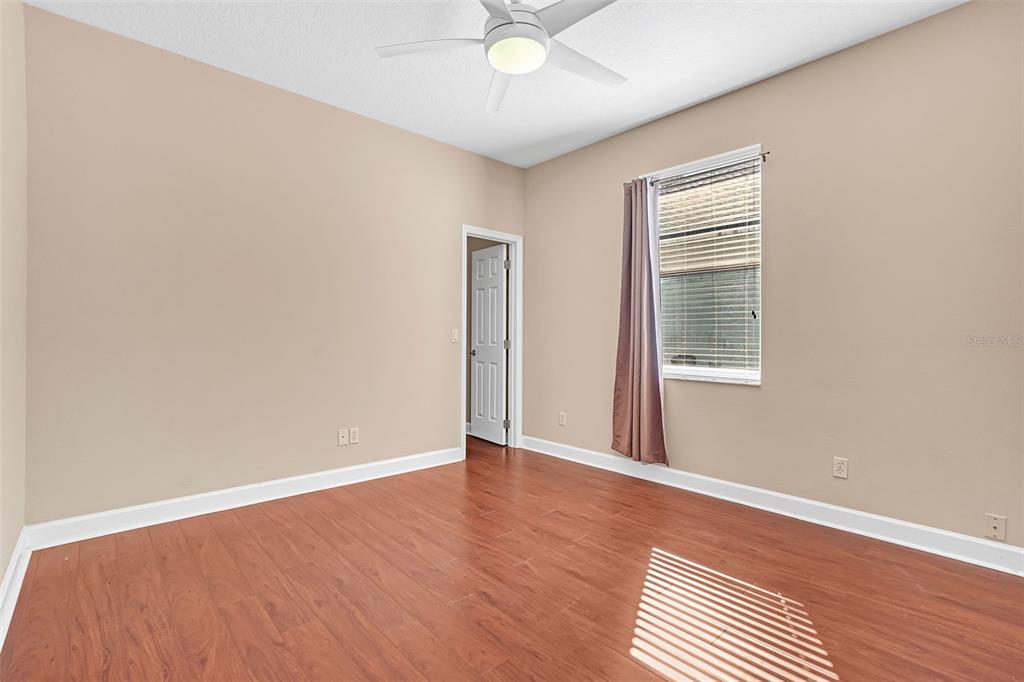 1542 Wescott Loop Winter Springs, FL 32708 - Photo 53 of 62 an empty room with wooden floor chandelier fan and windows