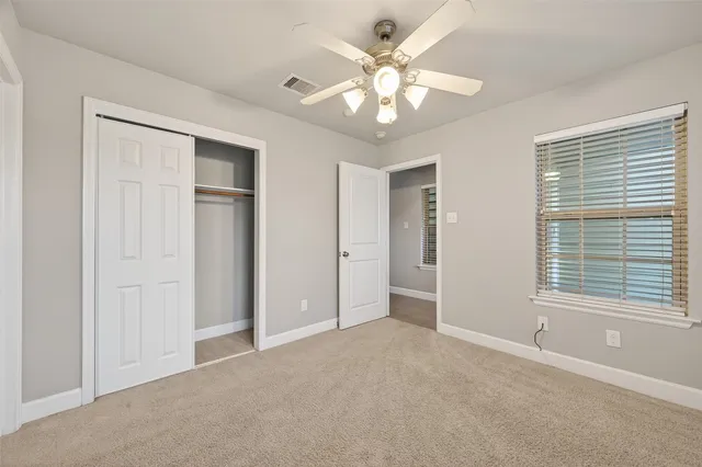 an empty room with windows and closet area