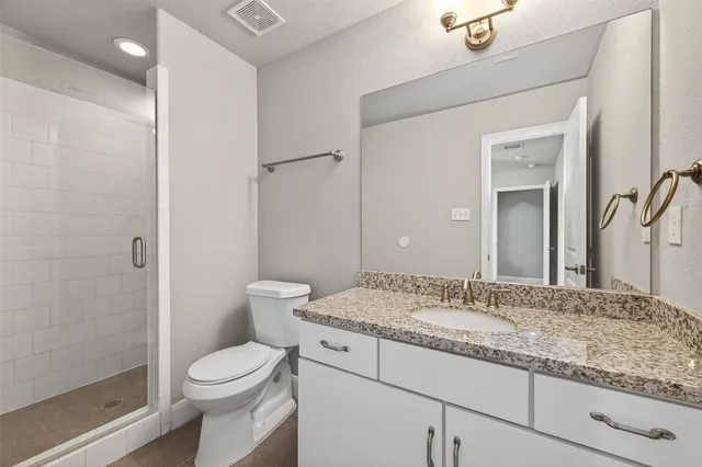a bathroom with a granite countertop sink toilet and shower