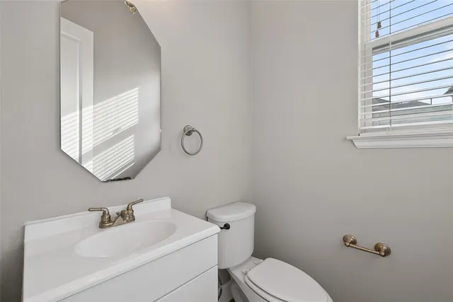 a bathroom with a sink mirror and toilet
