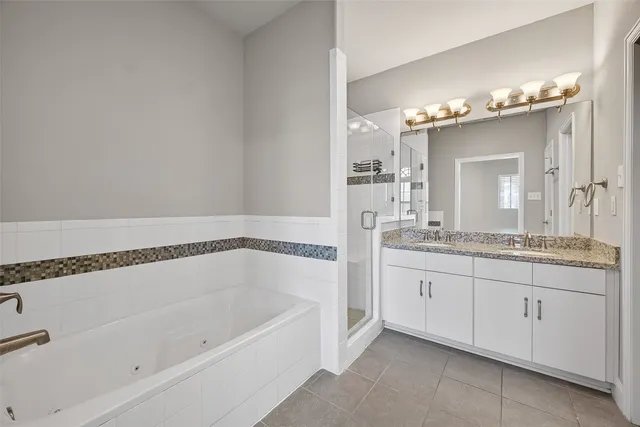 a bathroom with a granite countertop sink a mirror and a bathtub