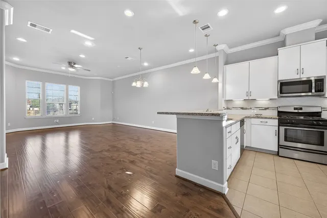 a kitchen with stainless steel appliances granite countertop a stove a sink and a microwave