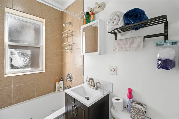 a bathroom with a sink vanity tub and a toilet