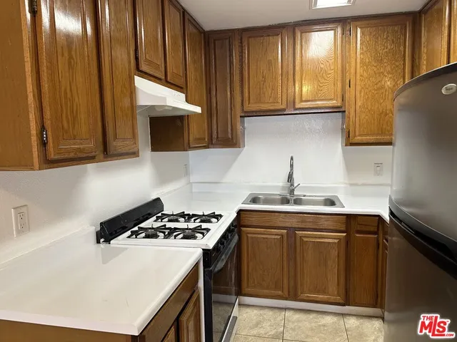a kitchen with a sink a stove and cabinets